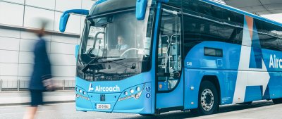 blue aircoach bus beside moving person